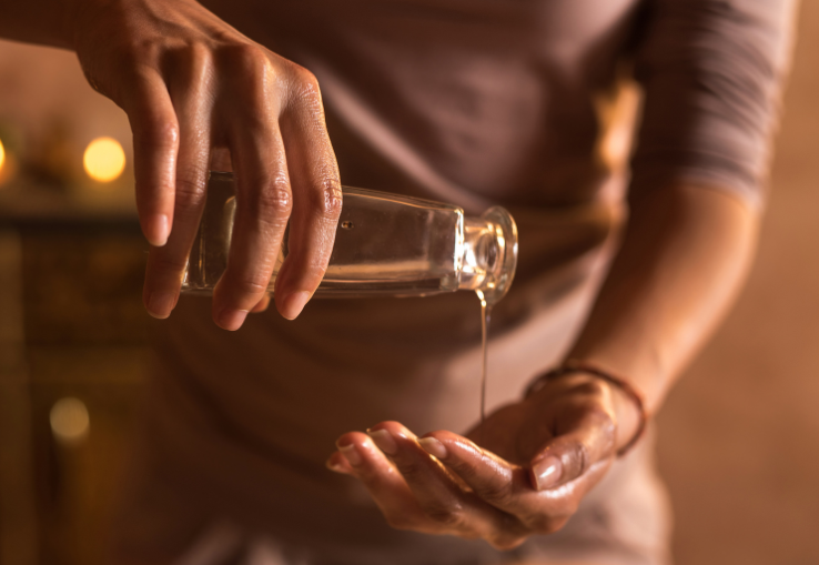 Mujer untando aceites ayurv&eacute;dicos en sus manos