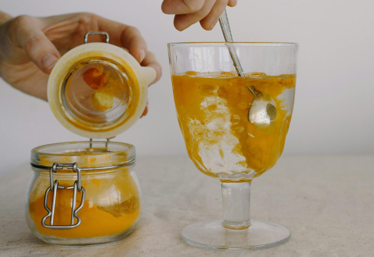 Vaso de agua con c&uacute;rcuma remedio ayurvedico antiinflamatorio